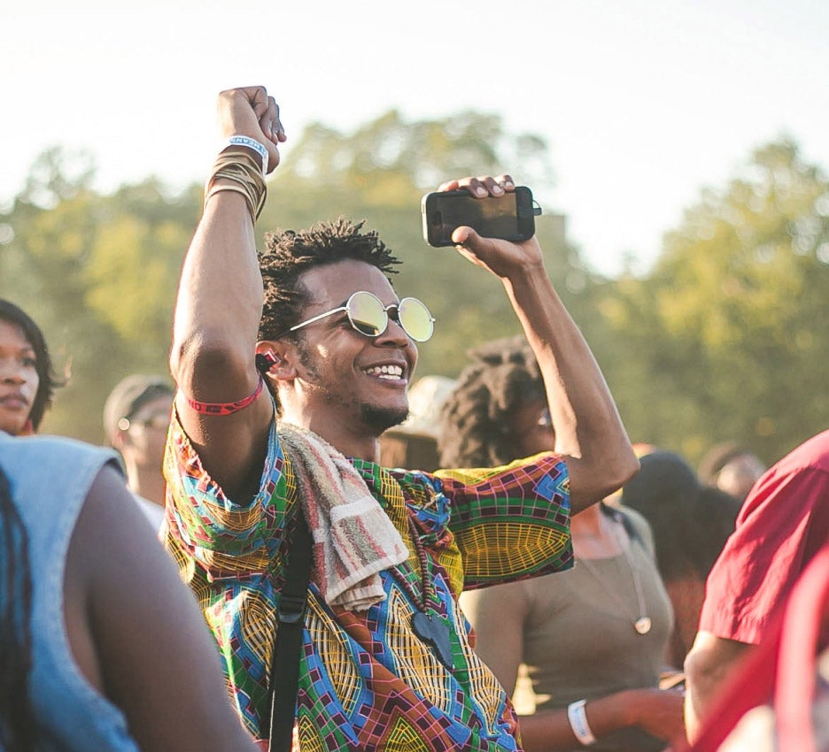 Photo of a smiling man dancing at a festival