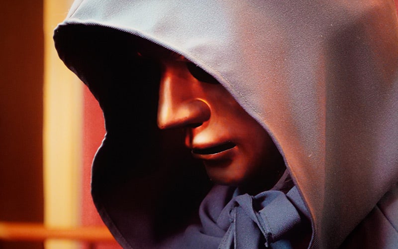 A masked figure in a hood